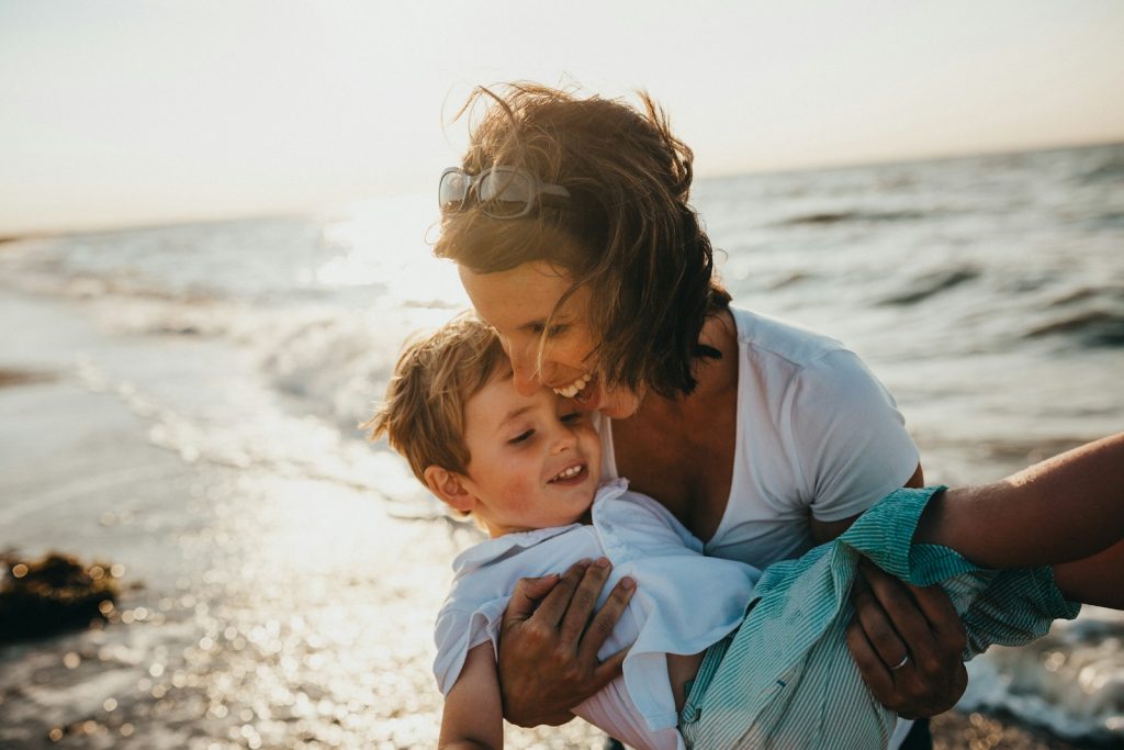 Foto von Mutter und Kind am Ufer eines Gewässers